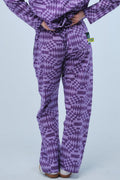 Person wearing a purple patterned outfit on a light blue background